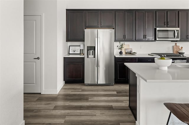 12547 Lake View St, Longmont, CO 80504 - kitchen featuring appliances with stainless steel finishes, light wood-style flooring, light countertops, and dark brown cabinetry