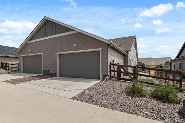 12547 Lake View St, Longmont, CO 80504 - view of property exterior with board and batten siding, concrete driveway, an attached garage, and a gate