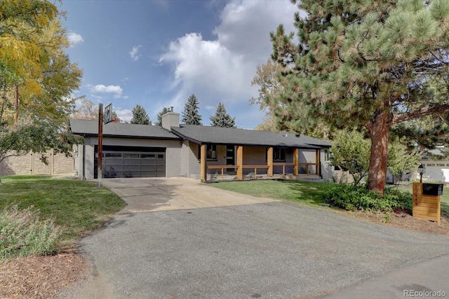 view of front facade with a porch, a garage, and a front lawn