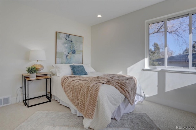 bedroom with multiple windows and light carpet