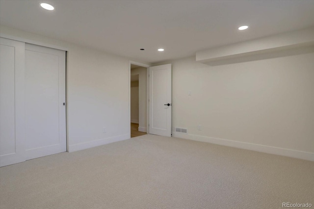 unfurnished bedroom with light carpet and a closet