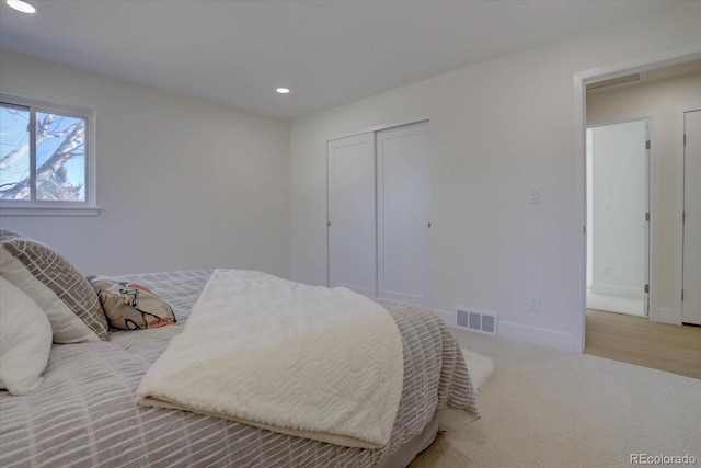 bedroom with light carpet and a closet