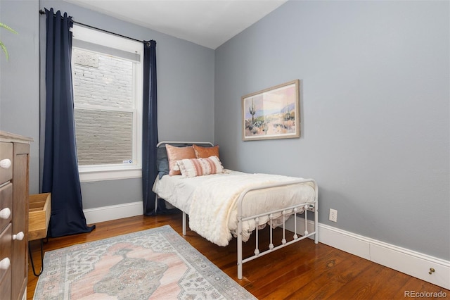 bedroom with wood finished floors and baseboards