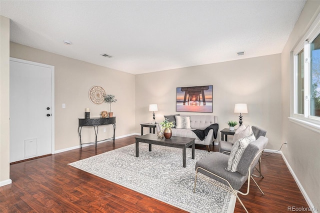 living room with a textured ceiling and dark hardwood / wood-style flooring