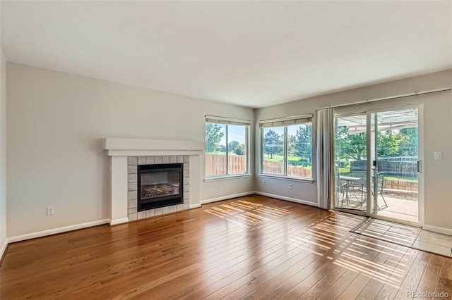 12701 Elm Ln, Broomfield, CO 80020 - unfurnished living room with hardwood / wood-style flooring and a tile fireplace