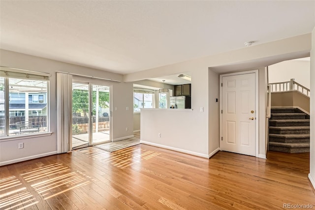 12701 Elm Ln, Broomfield, CO 80020 - unfurnished living room featuring light wood-style floors and stairway