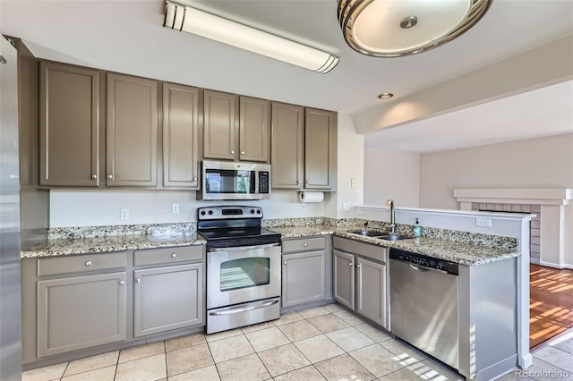 12701 Elm Ln, Broomfield, CO 80020 - kitchen featuring stainless steel appliances, gray cabinetry, a peninsula, light stone counters, and light tile patterned flooring