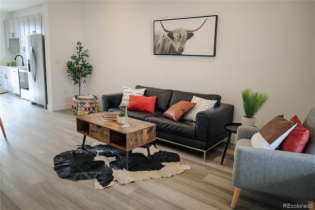 living area with baseboards and light wood finished floors