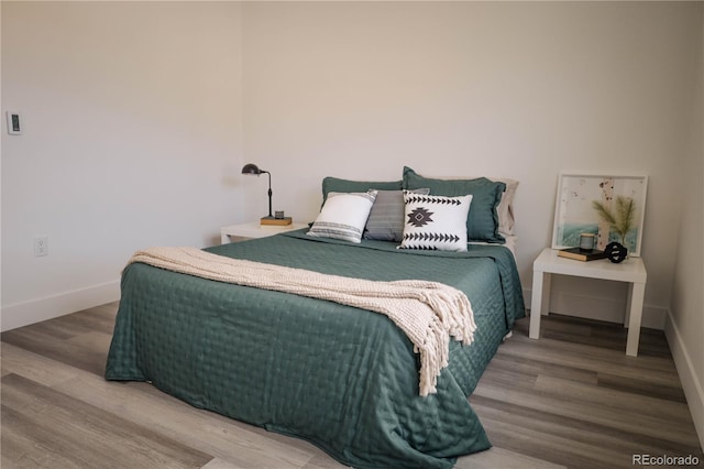 bedroom with baseboards and wood finished floors