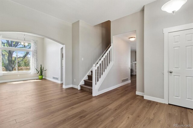 1462 Marigold Dr, Lafayette, CO 80026 - foyer entrance with arched walkways, wood finished floors, stairway, and baseboards