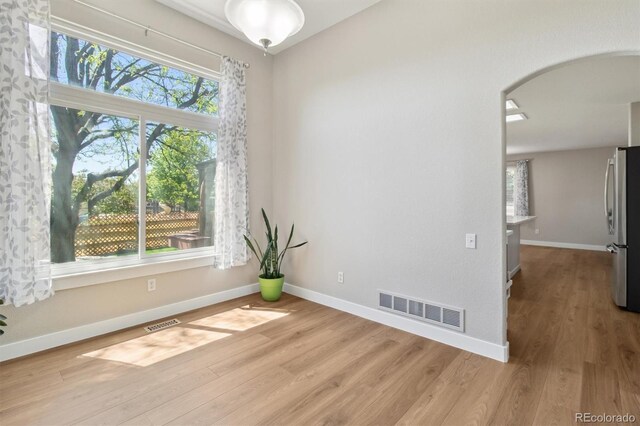 1462 Marigold Dr, Lafayette, CO 80026 - spare room featuring arched walkways, light wood-type flooring, and baseboards