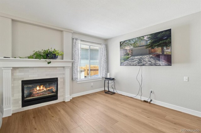 1462 Marigold Dr, Lafayette, CO 80026 - unfurnished living room with wood finished floors, a brick fireplace, and baseboards