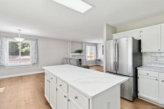 1462 Marigold Dr, Lafayette, CO 80026 - kitchen featuring freestanding refrigerator, a kitchen island, plenty of natural light, and white cabinets