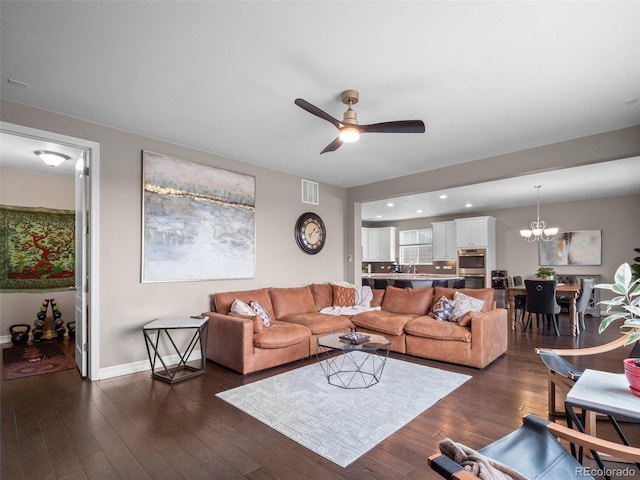 living room featuring ceiling fan with notable chandelier, sink, and dark hardwood / wood-style floors