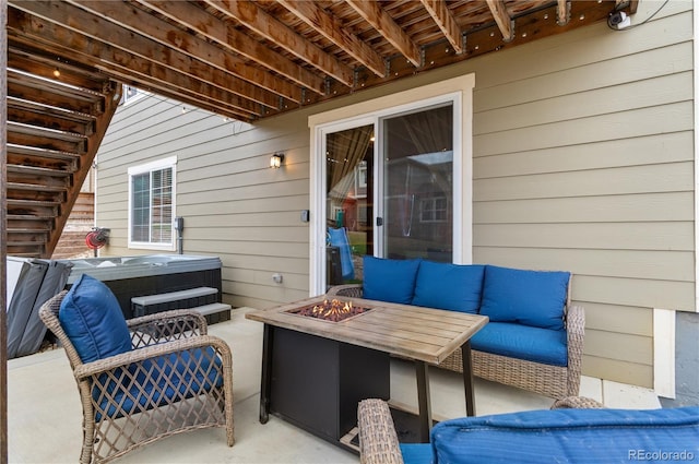 view of patio / terrace with an outdoor living space with a fire pit and a hot tub