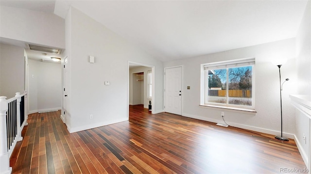 unfurnished living room featuring visible vents, vaulted ceiling, baseboards, and wood finished floors