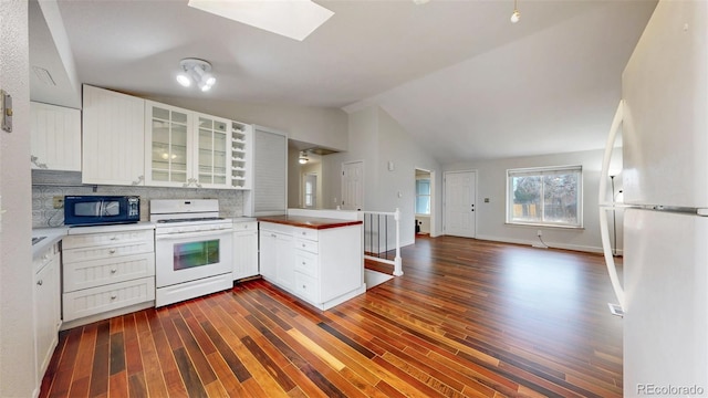 kitchen with white appliances, decorative backsplash, glass insert cabinets, open floor plan, and a peninsula