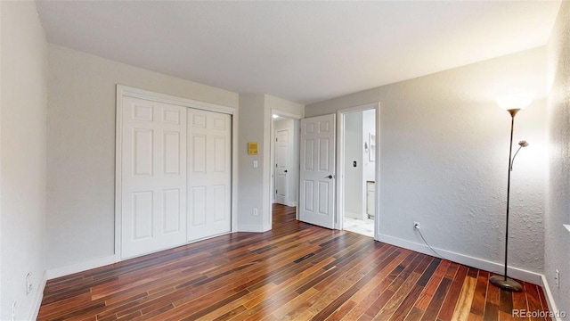 unfurnished bedroom with a closet, baseboards, and wood finished floors