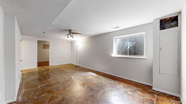 spare room with baseboards, visible vents, a ceiling fan, unfinished concrete floors, and a textured ceiling