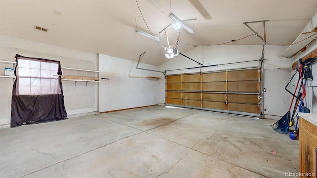 garage featuring a garage door opener and visible vents