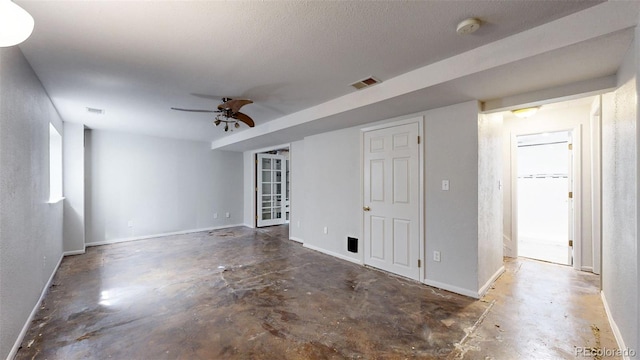 unfurnished room featuring baseboards, unfinished concrete floors, visible vents, and a ceiling fan