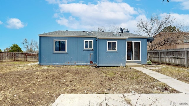 rear view of house with a fenced backyard