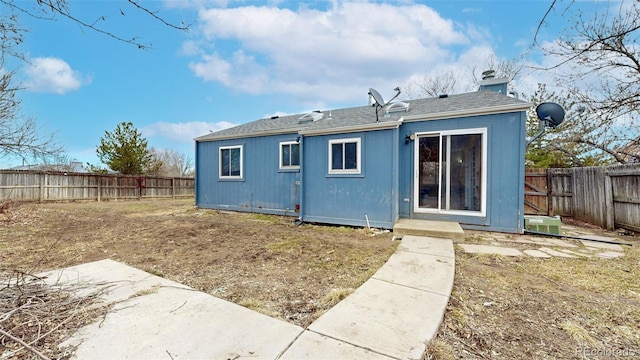 back of house featuring a chimney and a fenced backyard