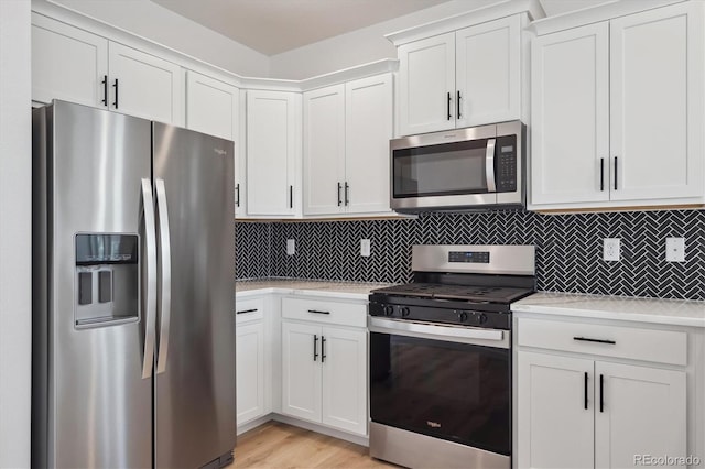 22363 E 6th Pl, Aurora, CO 80018 - kitchen featuring appliances with stainless steel finishes, light countertops, decorative backsplash, and white cabinets