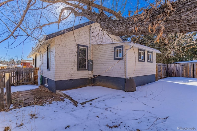 view of snow covered exterior with fence