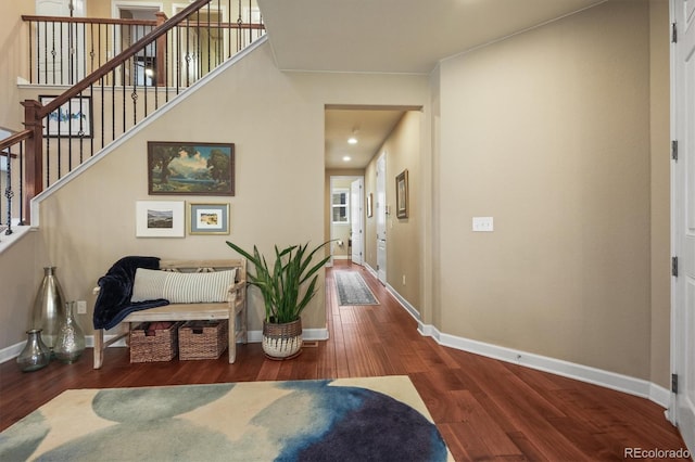 corridor featuring stairway, wood finished floors, and baseboards