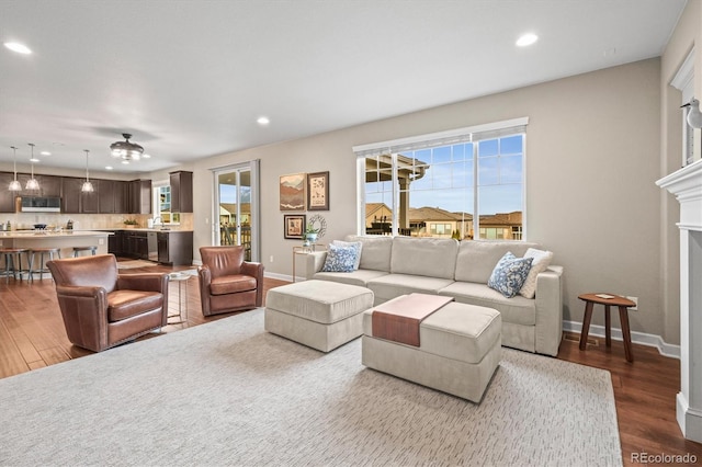 living area with dark wood-style floors, recessed lighting, a fireplace, and baseboards