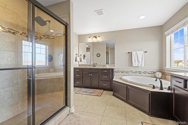 full bathroom featuring vanity, a shower stall, a garden tub, and visible vents