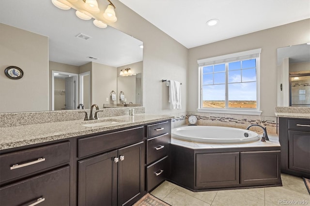 bathroom featuring tile patterned flooring, visible vents, vanity, and a garden tub