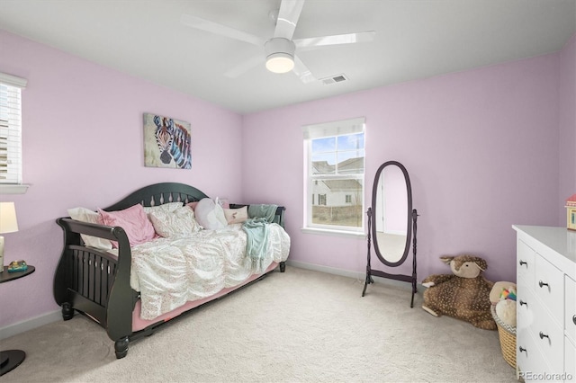 bedroom featuring visible vents, light colored carpet, baseboards, and a ceiling fan