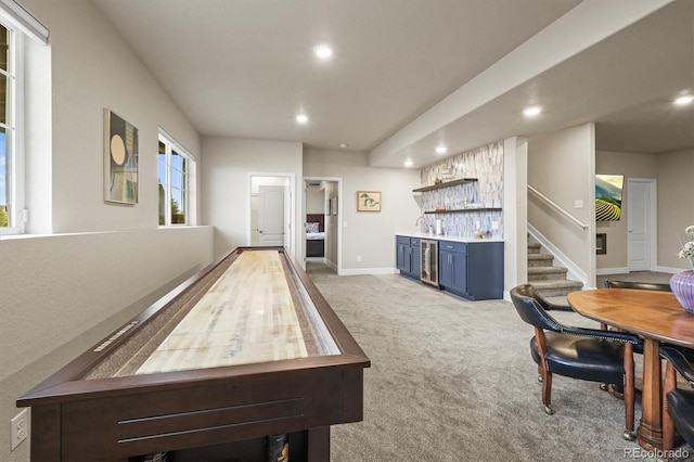 rec room featuring baseboards, beverage cooler, light colored carpet, a dry bar, and recessed lighting