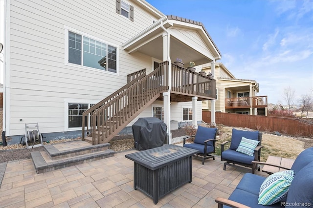 view of patio with grilling area, fence, a wooden deck, stairs, and outdoor lounge area