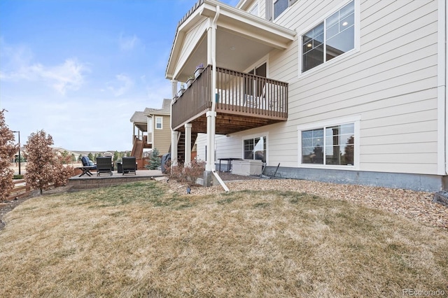 rear view of house with stairs, a patio, and a yard