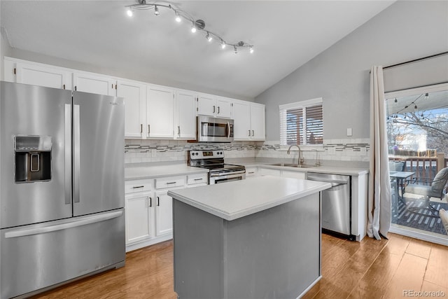 kitchen featuring a kitchen island, appliances with stainless steel finishes, a wealth of natural light, sink, and white cabinets