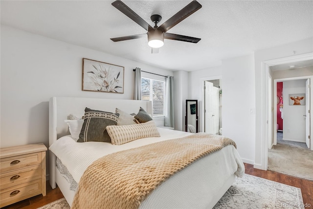 bedroom featuring dark hardwood / wood-style floors, a textured ceiling, and ceiling fan