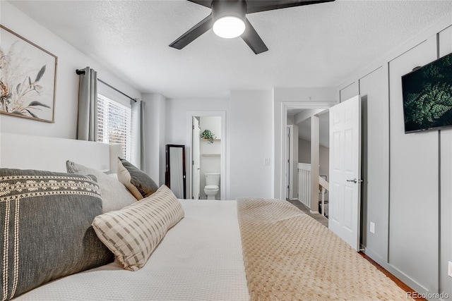 bedroom featuring ceiling fan, ensuite bath, and a textured ceiling