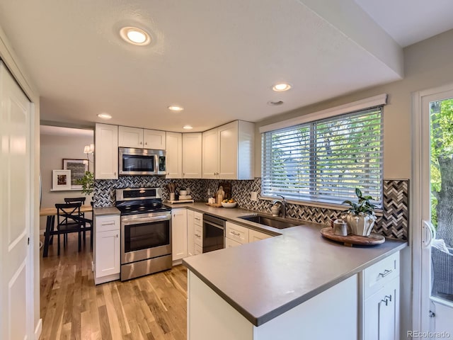 4196 S Reading Way, Denver, CO 80237 - kitchen with stainless steel appliances, a sink, white cabinetry, decorative backsplash, and recessed lighting