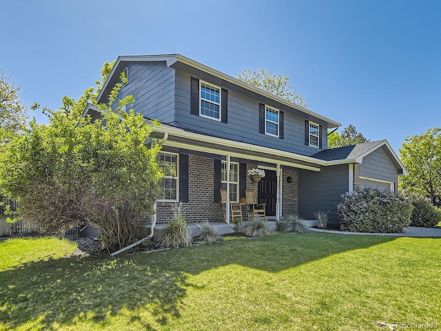 4196 S Reading Way, Denver, CO 80237 - traditional-style house featuring a garage, a porch, a front lawn, and brick siding