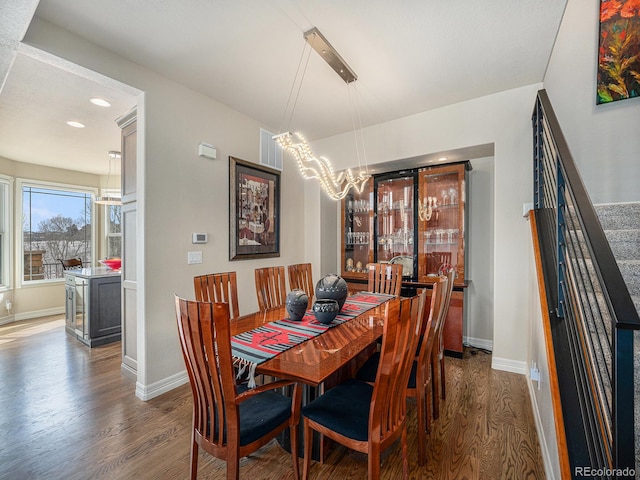 dining space with dark wood-type flooring and a chandelier