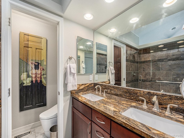 bathroom with tiled shower, vanity, and toilet