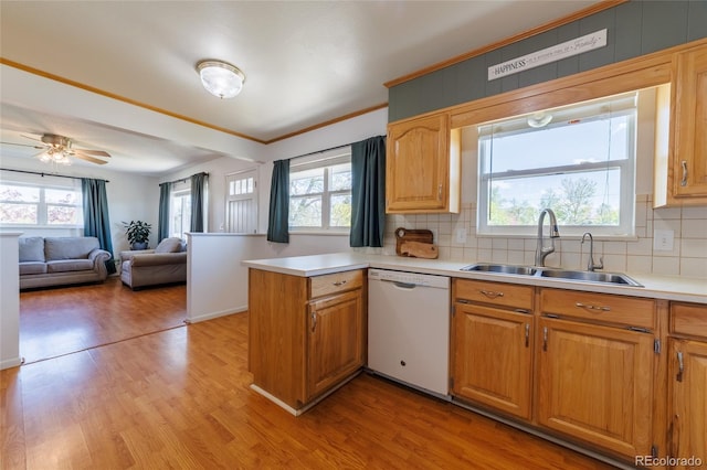 14347 E 134th Ave, Brighton, CO 80601 - kitchen with dishwasher, a sink, a peninsula, light wood finished floors, and backsplash
