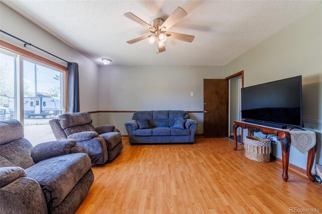 14347 E 134th Ave, Brighton, CO 80601 - living room featuring light wood-type flooring, a ceiling fan, and a textured ceiling