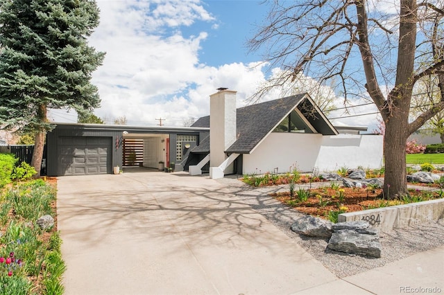 1884 S Ivy St, Denver, CO 80224 - view of front of home with roof with shingles, a chimney, driveway, and an attached garage