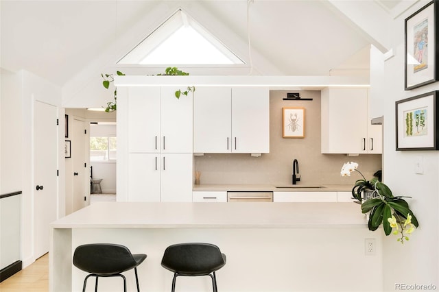 1884 S Ivy St, Denver, CO 80224 - kitchen featuring vaulted ceiling, a sink, a breakfast bar, and light countertops
