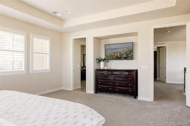 bedroom featuring a tray ceiling, light colored carpet, baseboards, and visible vents