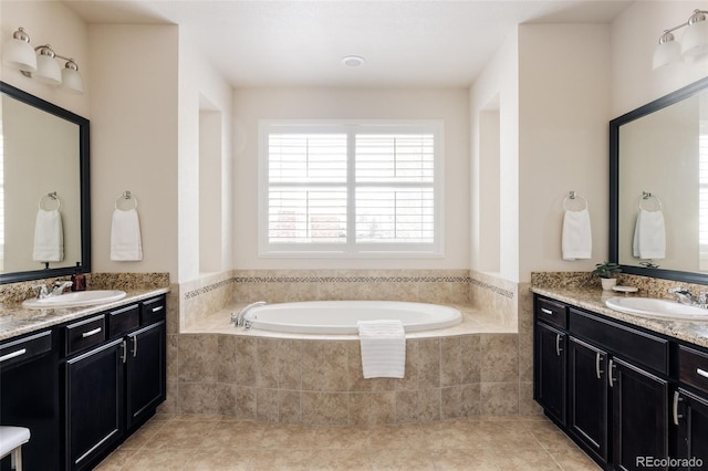 full bath featuring a garden tub, two vanities, tile patterned floors, and a sink